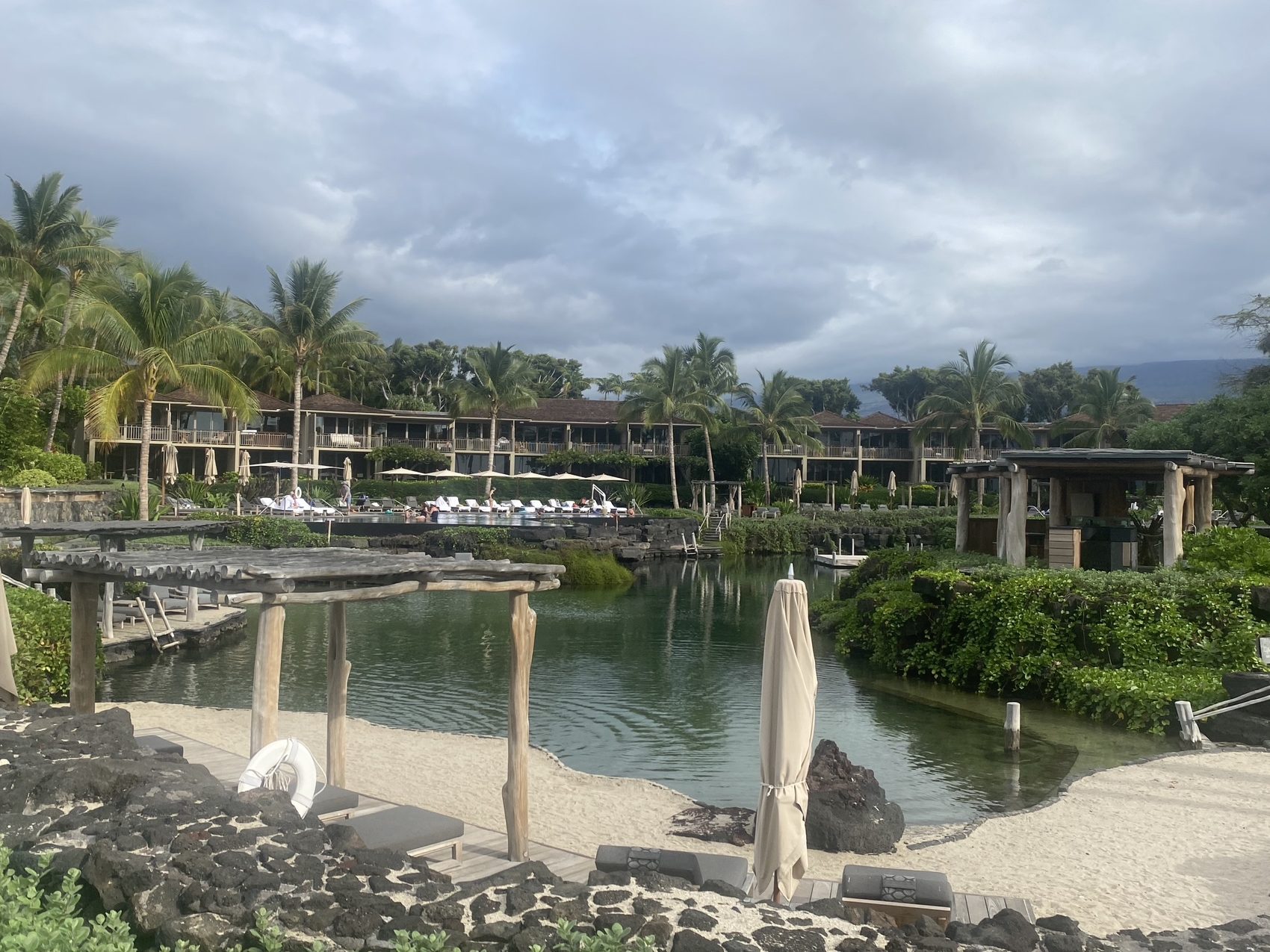 Lava rock, sand and the lagoon, looking back toward the rooms.