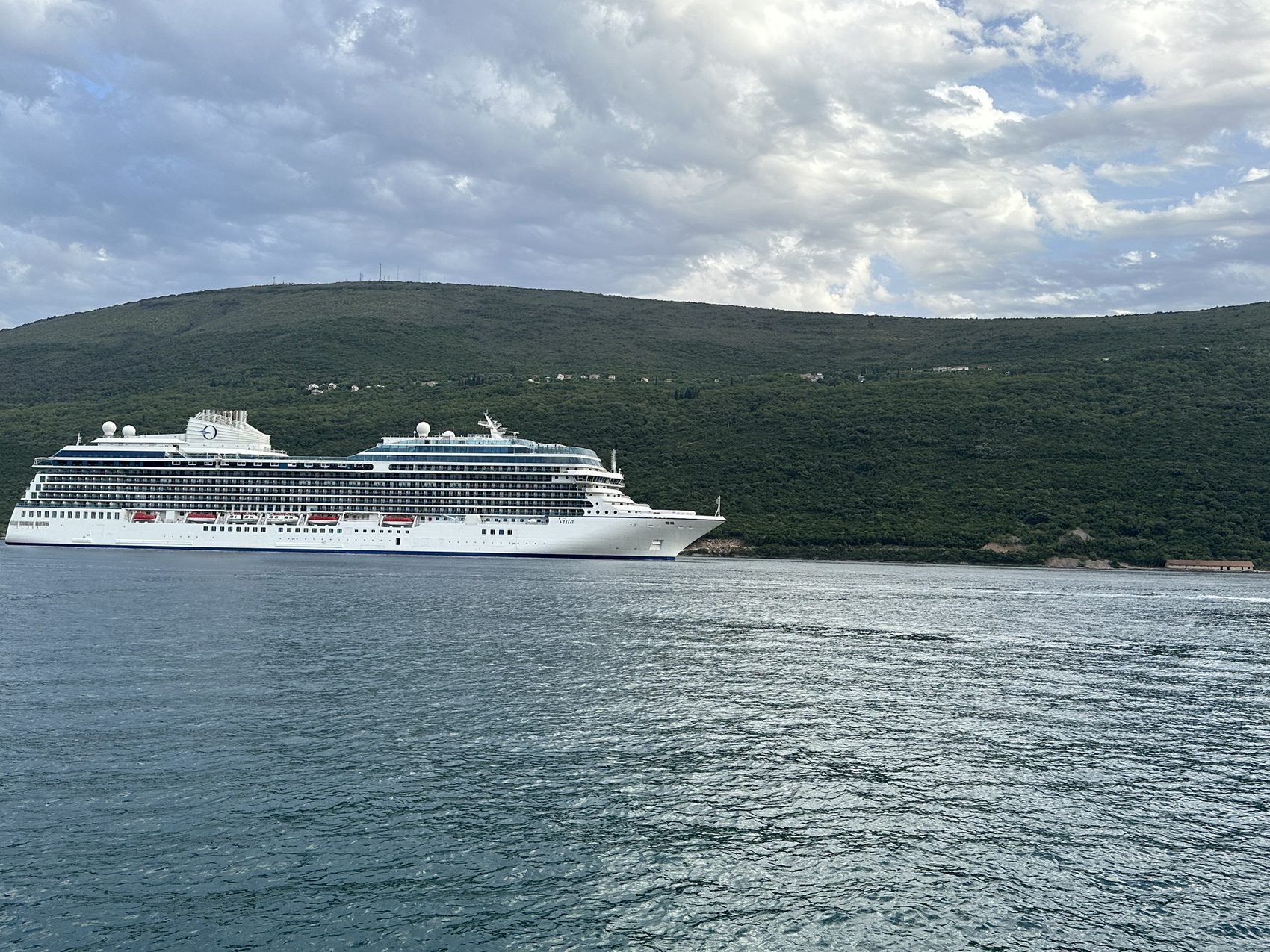A cruise ship coming up Boka Bay, dwarfed by the hills.